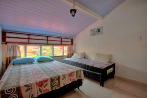 1 Schlafzimmer mit 2 Betten und einem Fenster in der Unterkunft EXCELENTE CASA EM CABO FRIO - BRAGA in Cabo Frio