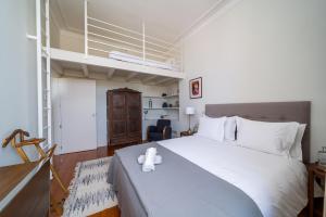 a bedroom with a large white bed in a room at Casa do Cativo in Porto