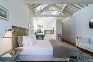 a bedroom with a large white bed and a couch at Casa do Cativo in Porto