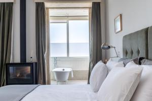 a bedroom with a bed and a bathroom with a tub at Casa do Cativo in Porto