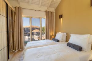two beds in a room with a large window at Kas Sumba in Water Villas in Kralendijk +23 photos