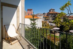 a balcony with a chair and a view of a city at Casa do Cativo in Porto