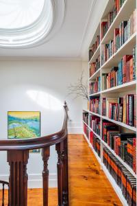 a library with large book shelves filled with books at Casa do Cativo in Porto