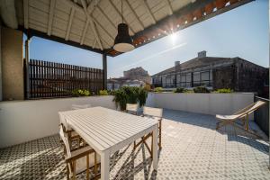 a white table and chairs on a balcony at Casa do Cativo in Porto