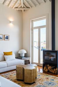 a living room with a white couch and a tv at Casa do Cativo in Porto