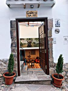 a door to a house with two potted plants at Gaia House Hostel in Cusco