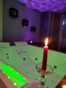una vela sobre una bañera en Loft avec Baignoire SPA LÉcrin Romantique, en Ochancourt