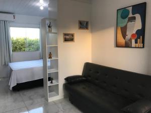 a living room with a couch and a bed at Residencial Campeche in Florianópolis