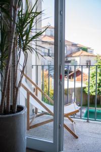 a sliding glass door with a bench on a balcony at Casa do Cativo in Porto