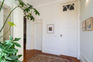 a hallway with a white door and a rug at Casa do Cativo in Porto