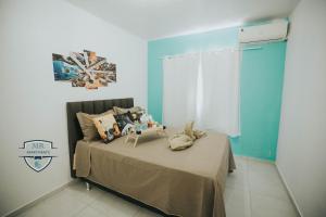 ein Schlafzimmer mit einem Bett und einer blauen Wand in der Unterkunft Recanto da Musica Maragogi l Condomínio com 4 casas in Maragogi + 97 Fotos