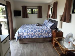una camera con un letto e un piumone blu e bianco di Wild Days Accommodation a Palm Beach