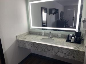 a bathroom with a sink with a large mirror at GreenTree Inn of Holbrook, AZ in Holbrook