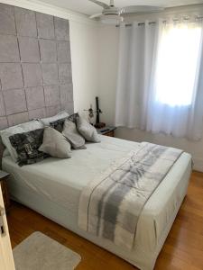 a large bed in a bedroom with a window at Quartos Vila Augusta/Guarulhos in Guarulhos