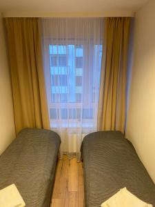 een slaapkamer met 2 bedden voor een raam bij Bengal Apartments in Szczecin