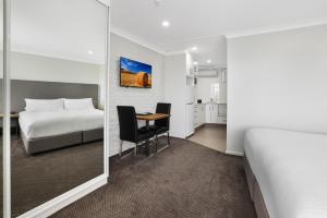 a hotel room with a bed and a table and chairs at The Duck Inn Apartments in Tamworth