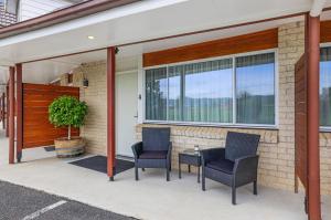 um pátio com duas cadeiras e uma mesa em frente a um edifício em The Duck Inn Apartments em Tamworth