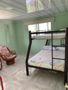 a bedroom with two bunk beds and a chair at Villa NiNa in Manizales