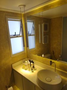 een badkamer met een wastafel en een spiegel bij Quartos Vila Augusta/Guarulhos in Guarulhos