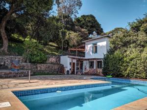 uma casa com piscina em frente a uma casa em Del Mundo Hostel em São João del Rei