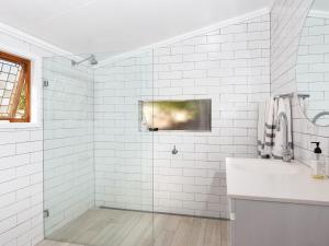 a white bathroom with a shower and a sink at Witts Oasis Two traditional Tea Gardens cottages in Tea Gardens +34 photos
