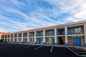 un gran edificio con puertas azules y aparcamiento en Motel 6-Cookeville, TN, en Cookeville