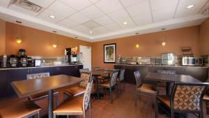 a restaurant with tables and chairs and a counter at Best Western Plus College Park Hotel in College Park