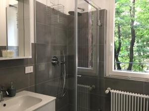 baño con ducha, lavabo y ventana en Domus Pyrus Apartments, en Pero