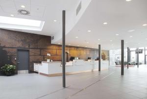 a lobby of a building with white counters at Scandic Sydhavnen in Copenhagen