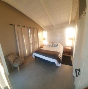 a bedroom with a bed and a chair at CABAÑA NORDICA in Los Laureles