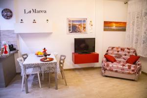 蒂勒尼亞的住宿－La Marea Monolocale sul mare，客厅配有桌子和椅子