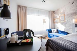 a hotel room with a bedroom with a bed and a table at Scandic Kuopio in Kuopio