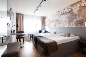 a bedroom with a large bed and a table at Scandic Kuopio in Kuopio
