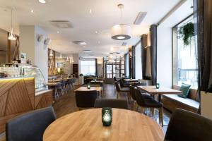 a restaurant with tables and chairs and a bar at Scandic Plaza Turku in Turku