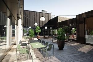 eine Terrasse mit einem grünen Tisch und Stühlen auf einem Gebäude in der Unterkunft Scandic Hamar in Hamar