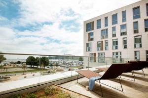 a balcony with chairs and a view of a building at Scandic Kristiansand Bystranda in Kristiansand