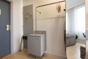 a bathroom with a sink, toilet, and cabinet at Scandic Byporten in Oslo