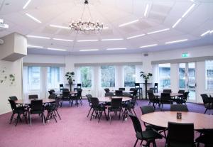 a large room with tables and chairs and windows at Scandic Plaza Borås in Borås