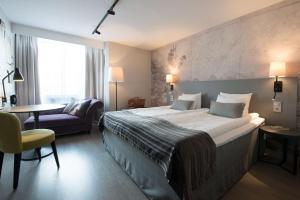 una habitación de hotel con una cama grande y una silla en Scandic Crown en Gotemburgo