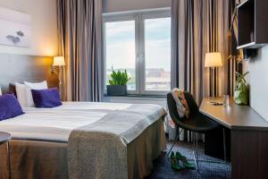 una camera d'albergo con letto, scrivania e finestra di Scandic No. 25 a Göteborg