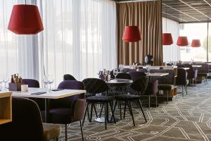 延雪平的住宿－斯堪迪克艾爾米亞酒店，一间带桌椅和红灯的用餐室