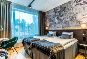 two beds in a hotel room with a mural on the wall at Scandic Frimurarehotellet in Linköping
