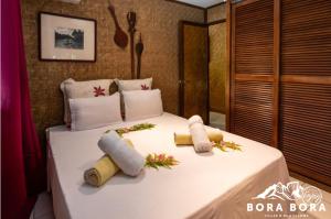 un letto bianco con due asciugamani sopra di Villa Bora Bora - on Matira a Bora Bora
