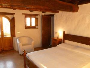 a bedroom with a bed and a chair and a window at Della Genga Resort in Arezzola +36 photos