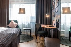 una camera d'albergo con scrivania e letto di Scandic Infra City a Upplands Väsby
