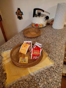 a counter with a basket of food and a tea kettle at La casa di Grace nella valle incantantata in Carano