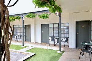 a patio with chairs and tables in a building at Guichen Bay Motel in Robe