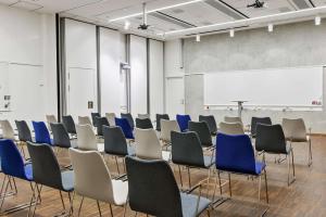 a room with rows of chairs and a whiteboard at Scandic Klara in Stockholm