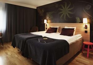 a bedroom with a large bed with a black wall at Scandic Upplands Väsby in Upplands-Väsby