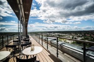 balcón con mesas y sillas y vistas a la ciudad en Scandic Talk, en Estocolmo